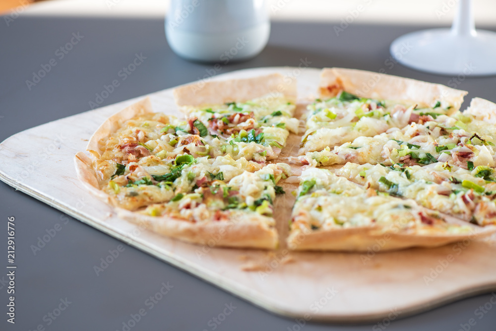 Original dünner Flammkuchen aus dem Elsass mit Zwiebeln, Speck und Sauerrahm Creme im Ofen gebacken 