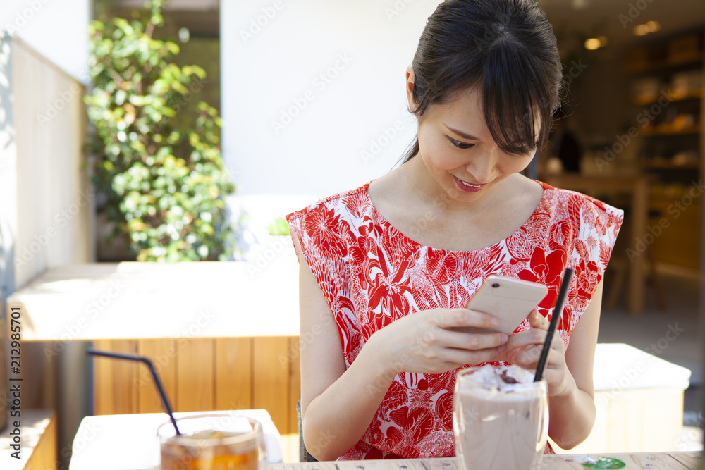 ドリンクを飲みながら、スマートフォンを操作している女性たち。