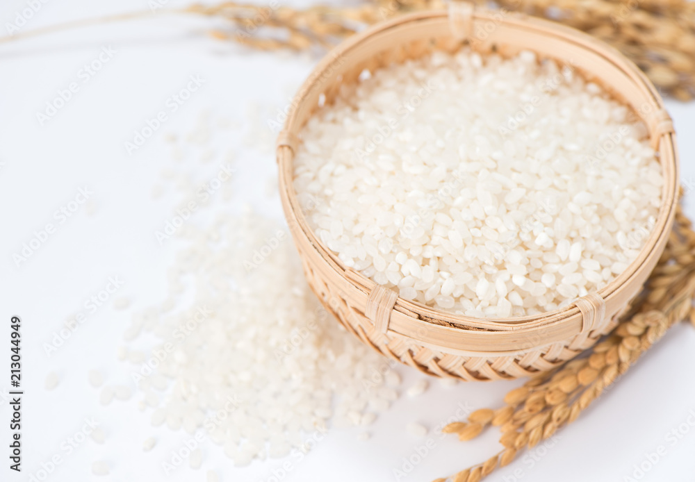 white rice in wooden bowl and unmilled rice isolated on white background