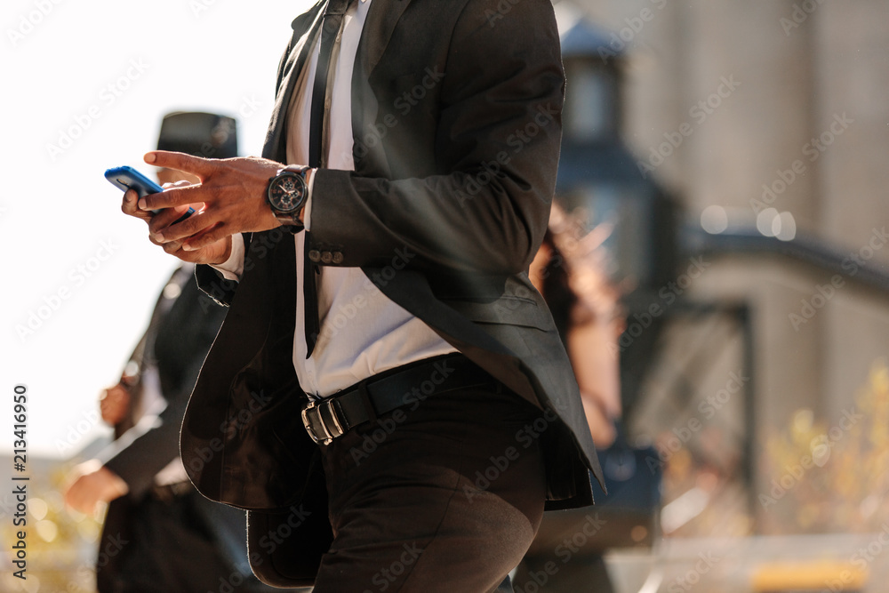 Man using mobile phone while walking on street