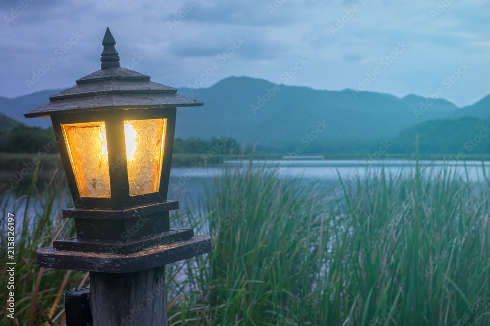 日落时分，山背景的旧灯架发出的橙色光