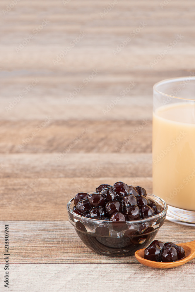 Tapioca Pearl , Bubble topping for tea or other beverage, in a cup, place on wooden table. Copy spac