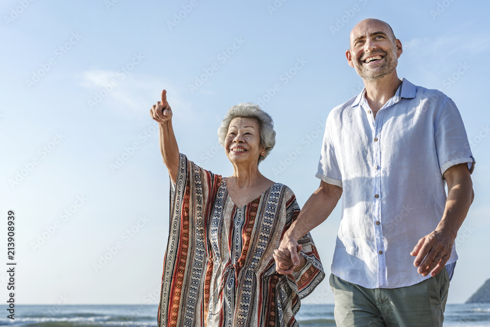 在海滩上一起散步的成熟夫妇