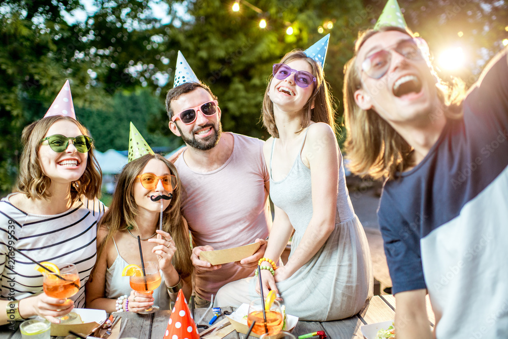 Happy friends having fun together making selfie photo during the celebration at the outdoor park caf