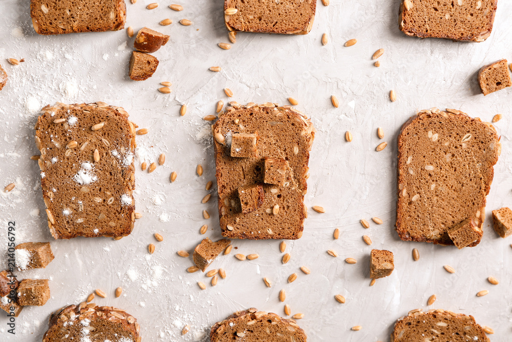 Flat lay composition with slices of freshly baked rye bread on gray background