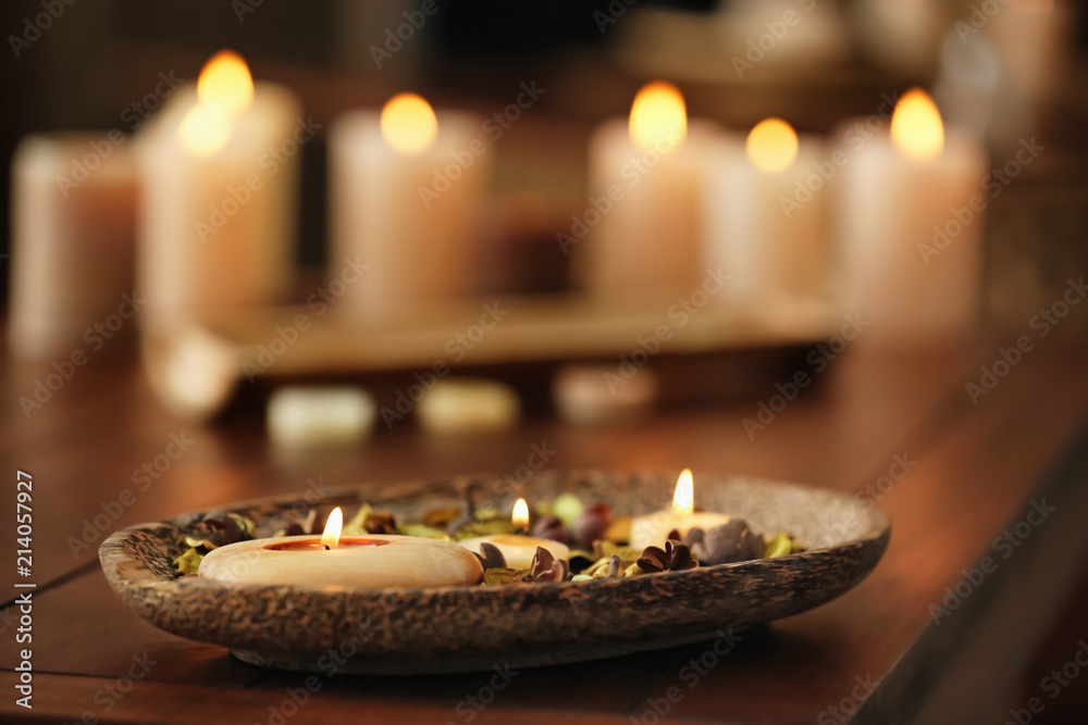 Burning candles on table in spa salon