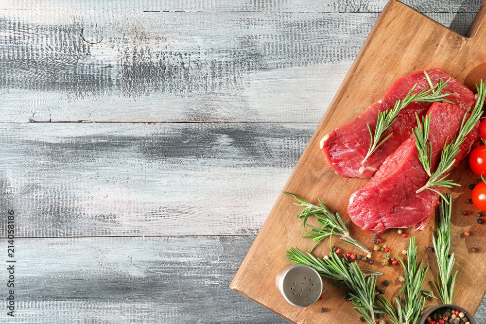 Flat lay composition with fresh raw meat and rosemary on wooden background