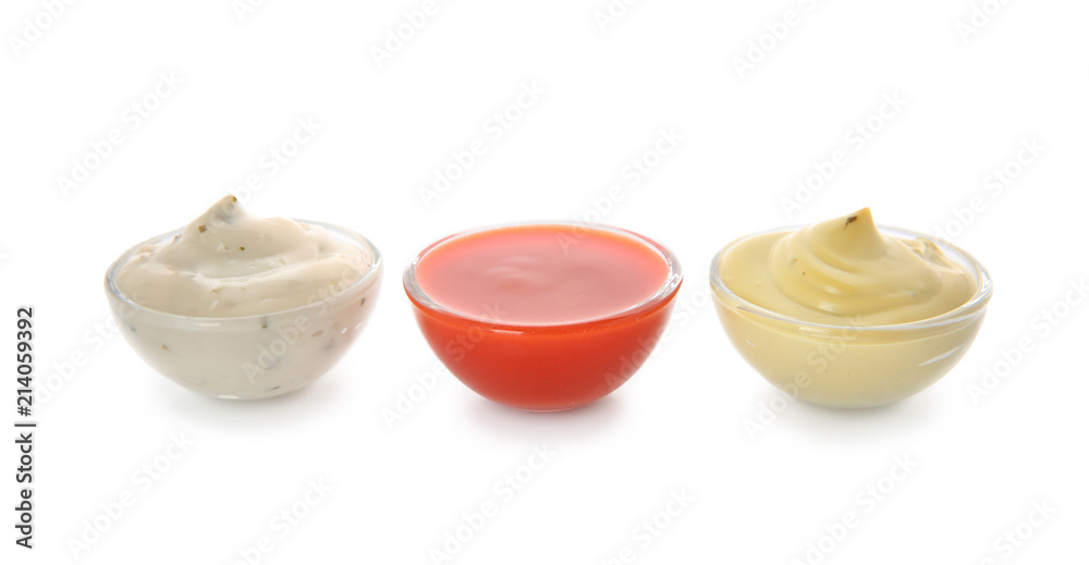 Bowls with different sauces on white background