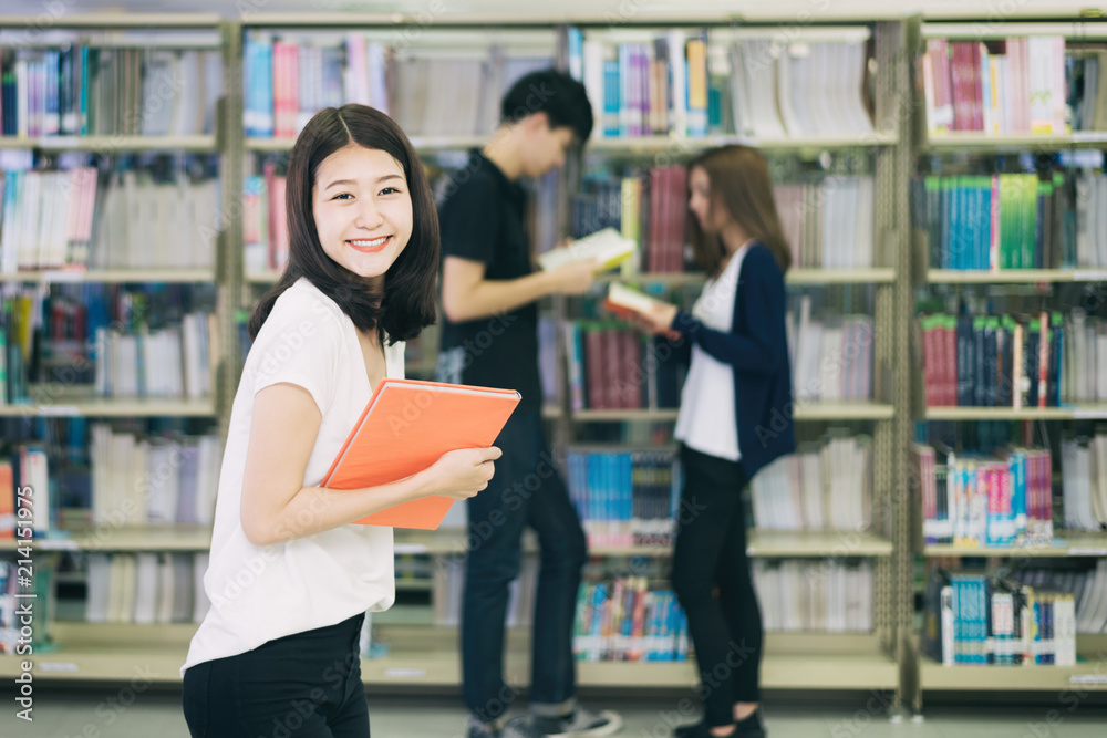 一群亚洲学生在大学图书馆一起学习。大学生。快乐女孩