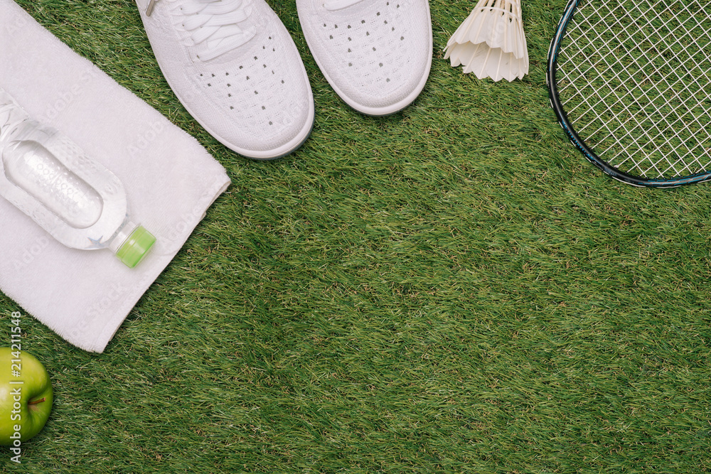 Top view of various sport equipment on green grass