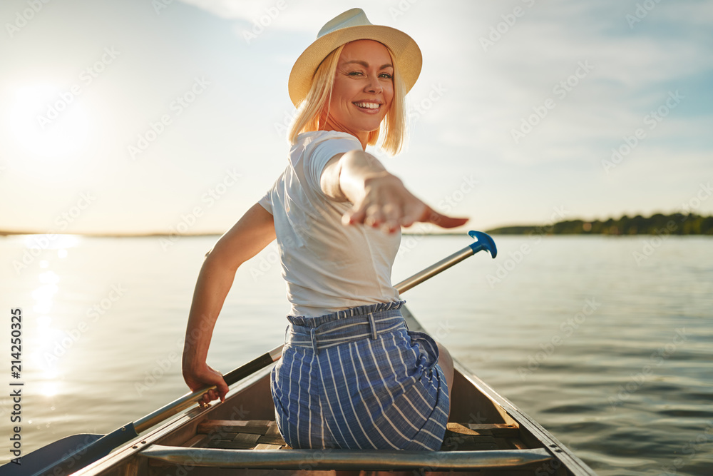 Smiling woman canoeing on a scenic lake in the summer