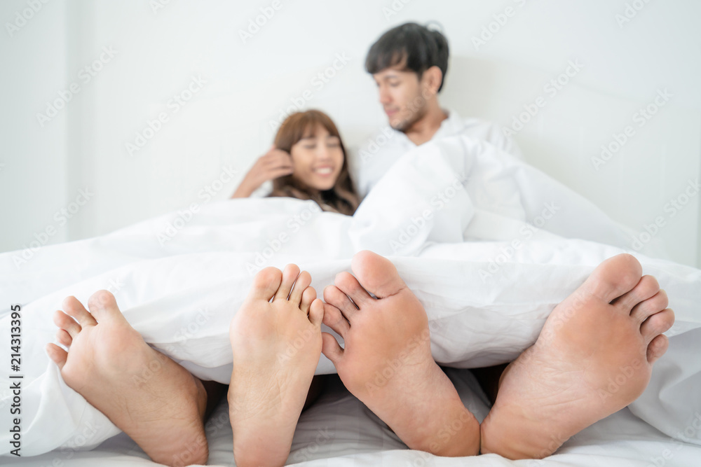 Happy young couple relaxing in the home bedroom.