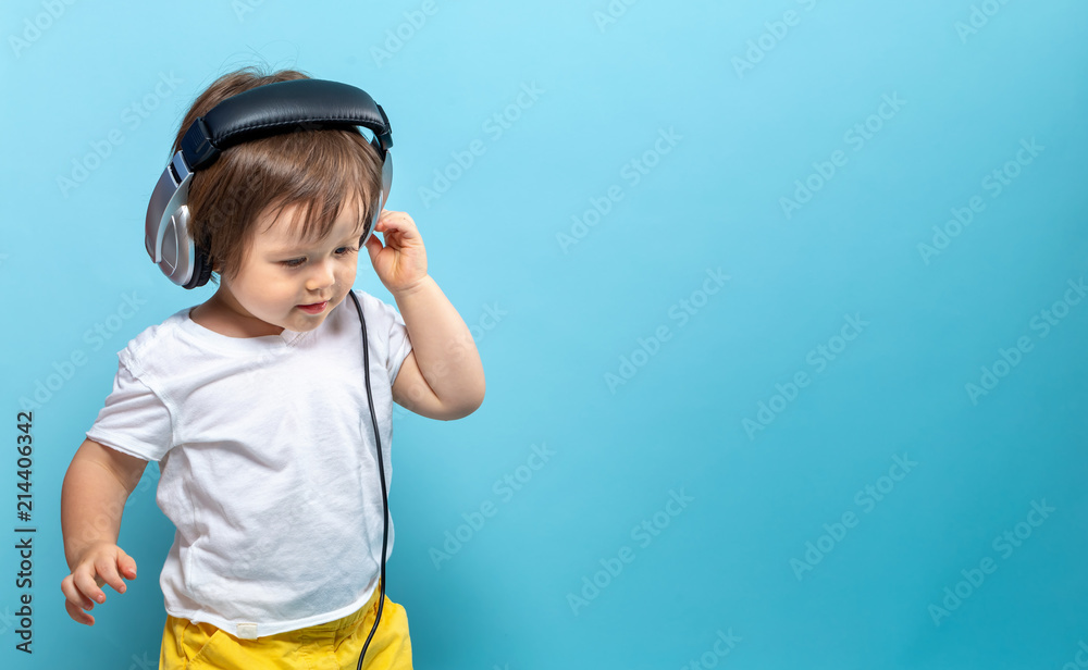 Toddler boy with headphones on a blue background