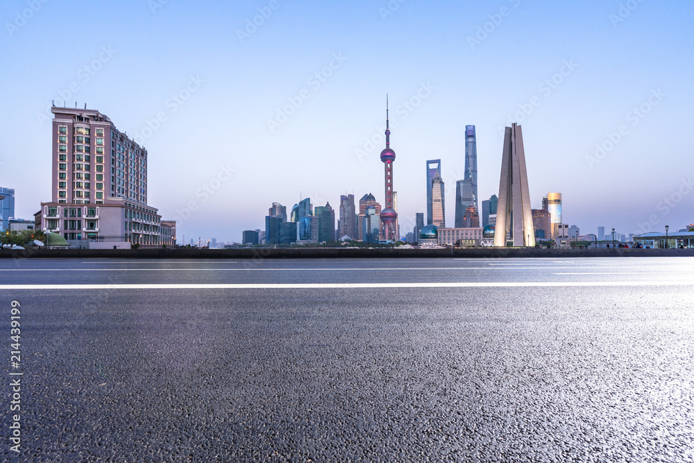 empty asphalt road with city skyline