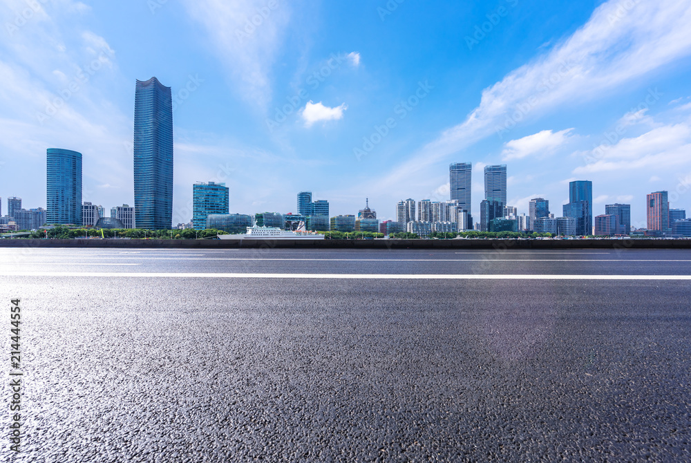 empty asphalt road with city skyline