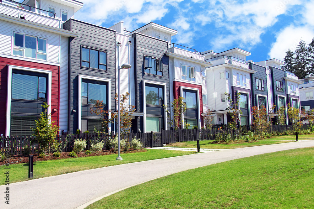 Beautiful new contempory suburban attached townhomes with colorful summer gardens in a Canadian neig