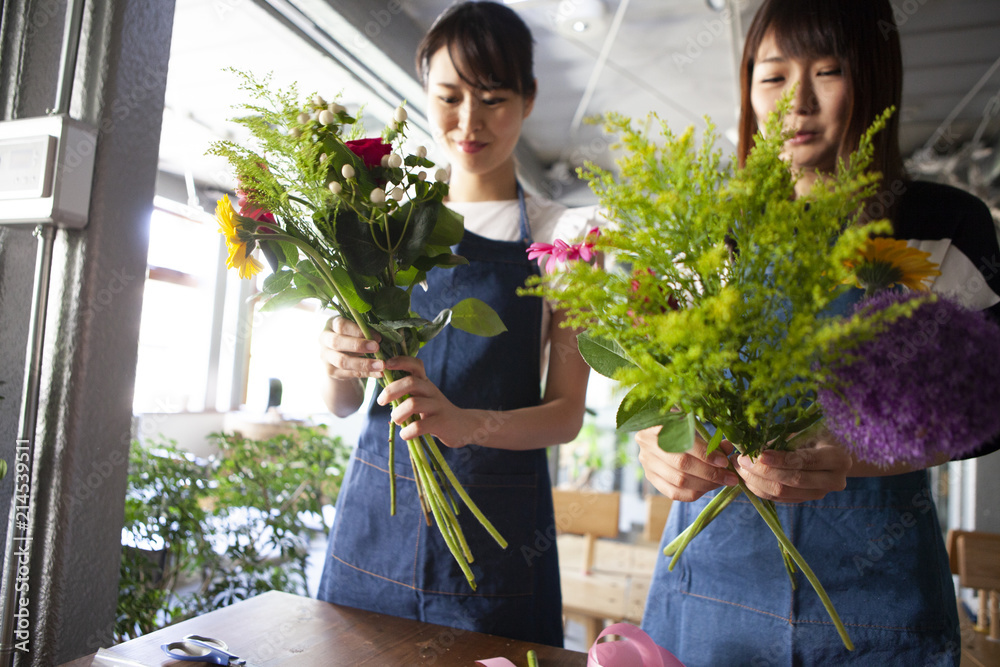 フラワーアレンジメント教室で楽しそうに花束を作る女性二人