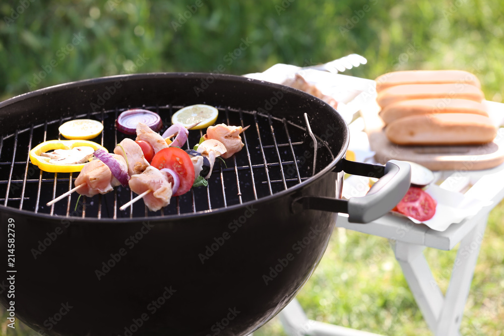 户外烧烤架上的烤肉串配生肉和蔬菜