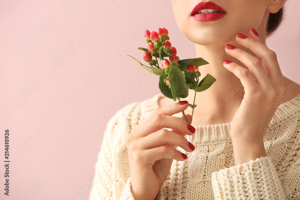 Young woman with beautiful manicure and branch on color background