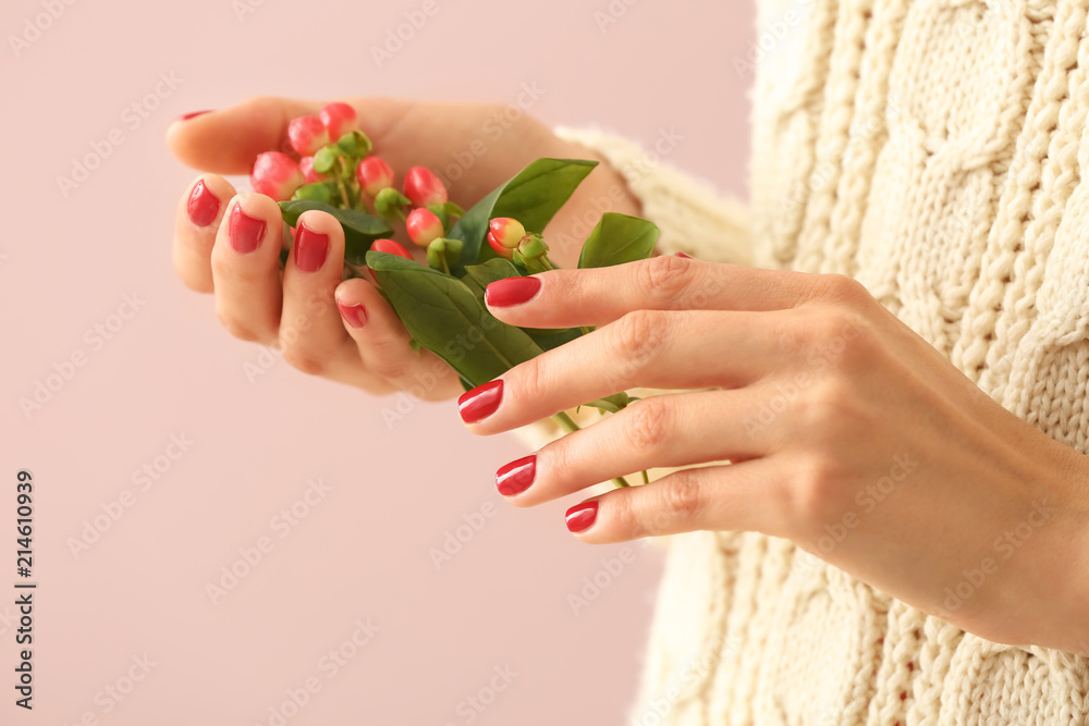 Young woman with beautiful manicure and branch on color background, closeup