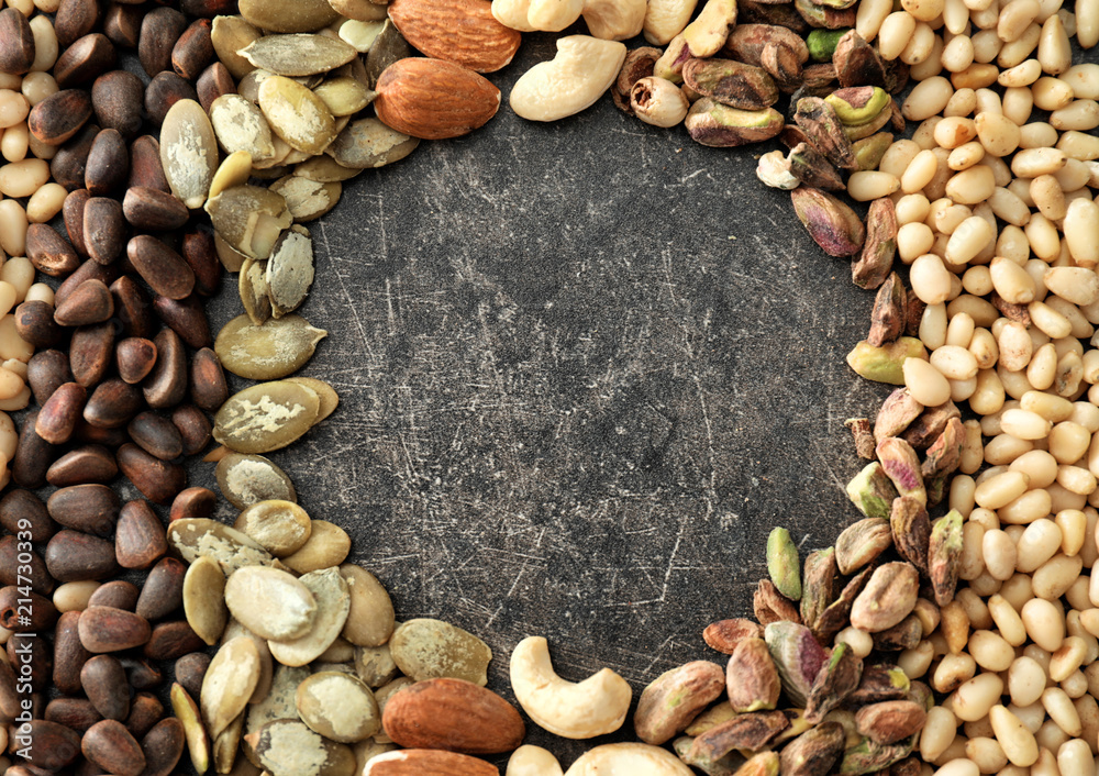 Frame made of different nuts on grey background