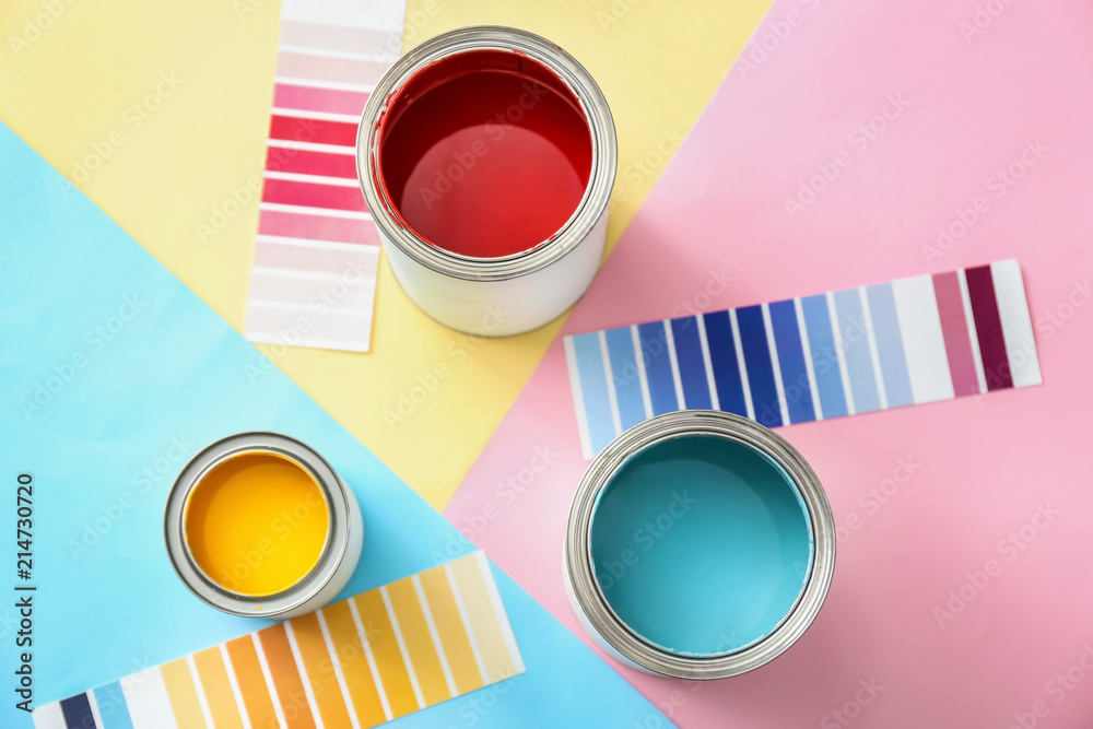 Paint cans with palette samples on color background