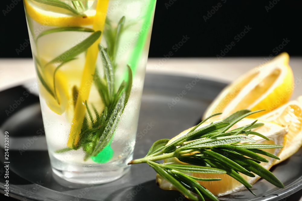 Fresh lemonade with rosemary in glass on tray, closeup