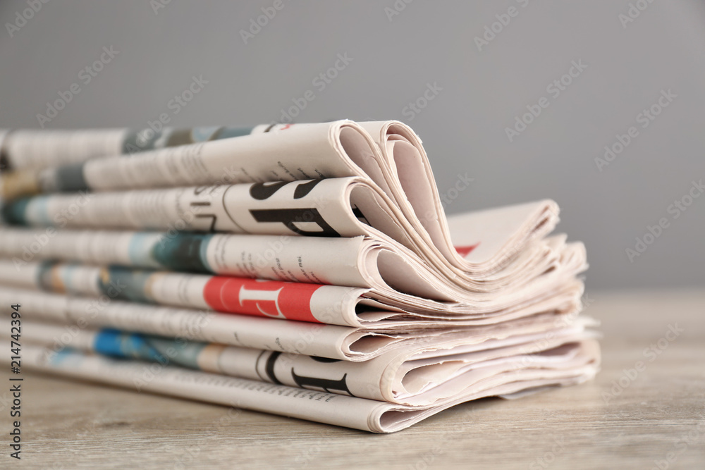 Pile of various newspapers on table