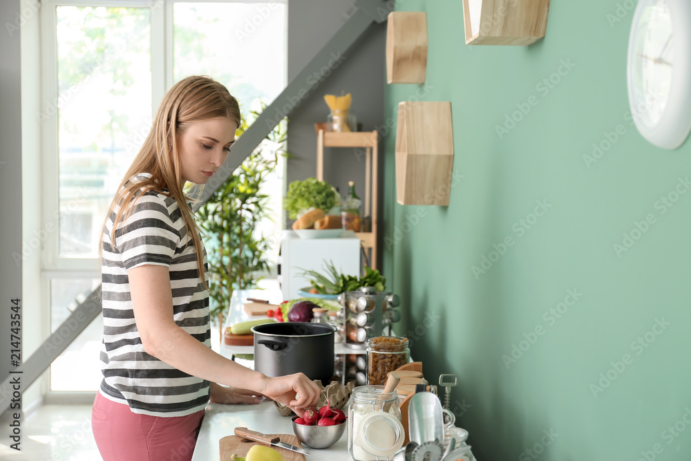 Young woman cooking in kitchen