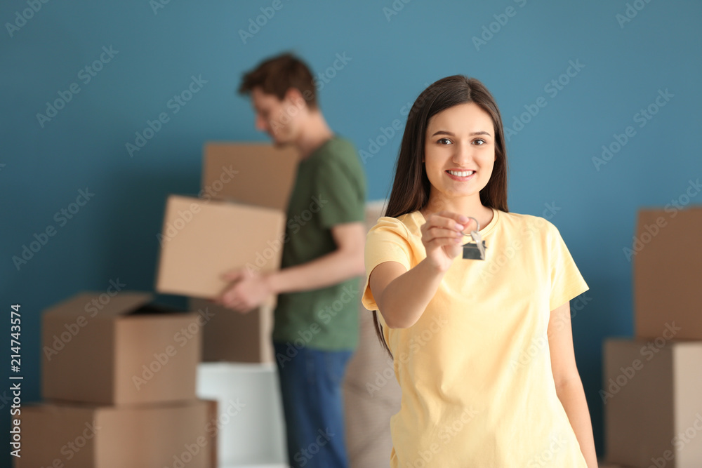 Young happy woman with key at new home