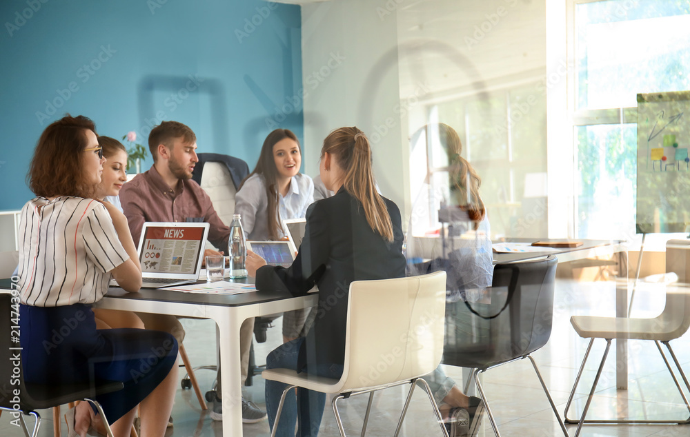 View at business team during meeting in office through transparent board