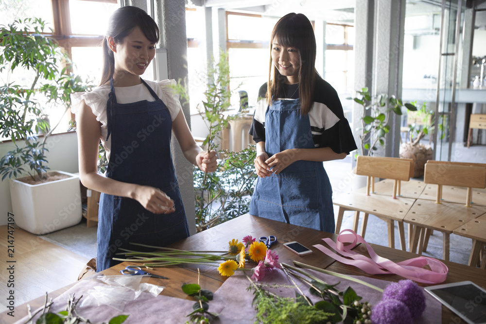 お客様の花束を丁寧に考えながら作る花屋の女性店員二人