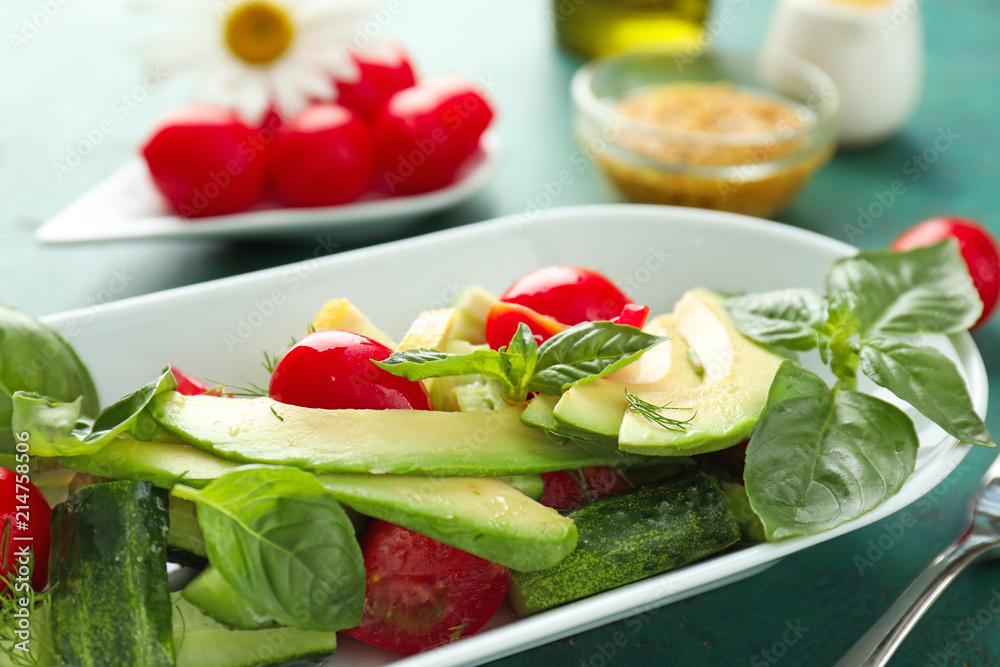 Tasty salad with avocado and tomatoes on plate, closeup