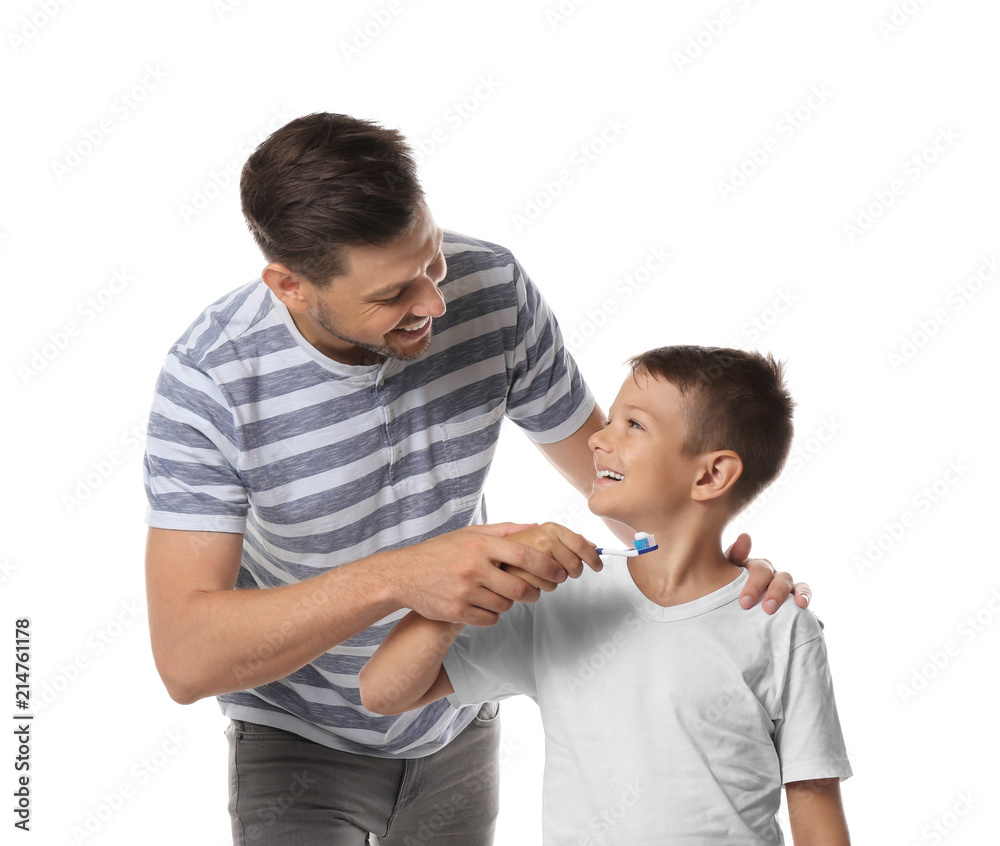 Man teaching his little son how to brush teeth on white background