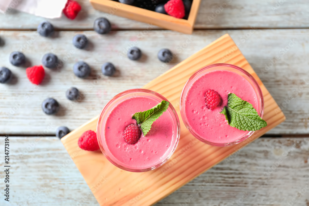 Glasses with tasty raspberry smoothie on wooden table