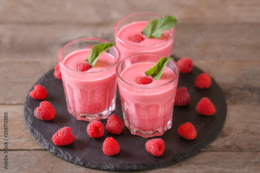 Glasses with tasty raspberry smoothie on wooden table