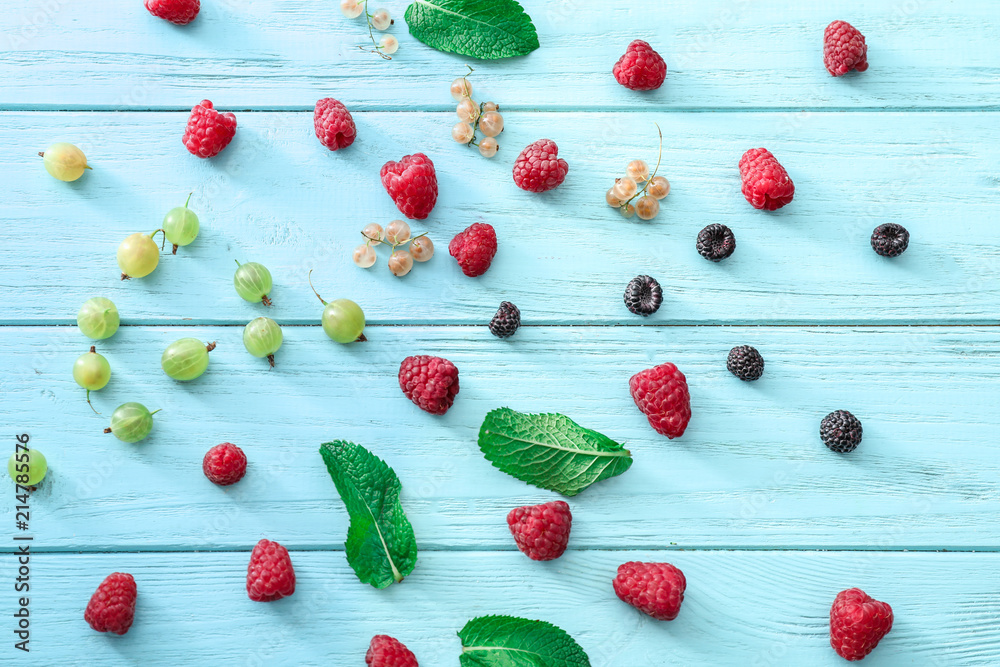 Fresh ripe berries on color wooden background