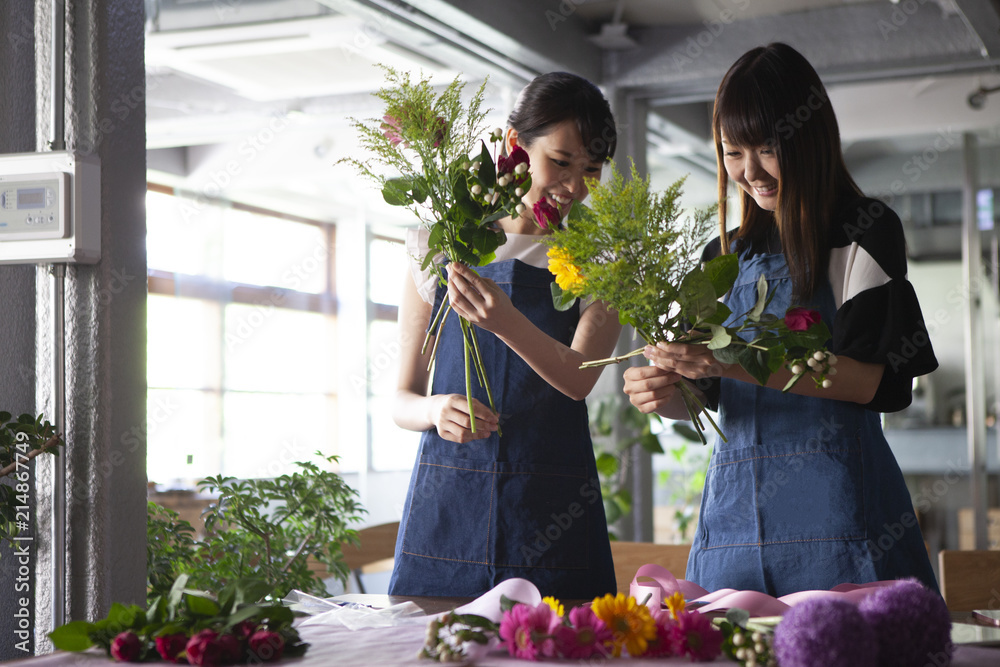 お花の教室で楽しそうに花束を作る女性二人