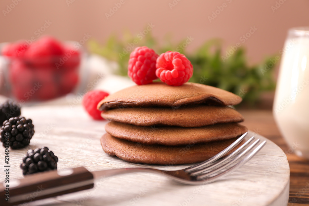 Stand with tasty chocolate pancakes on wooden table, closeup