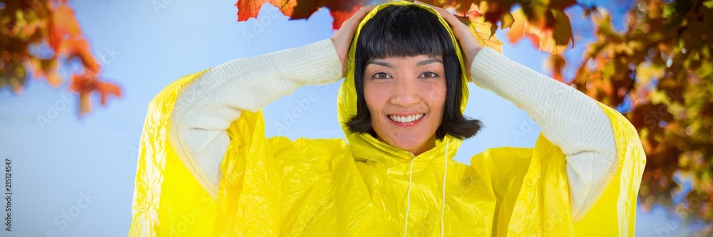 Composite image of woman wearing yellow raincoat against white