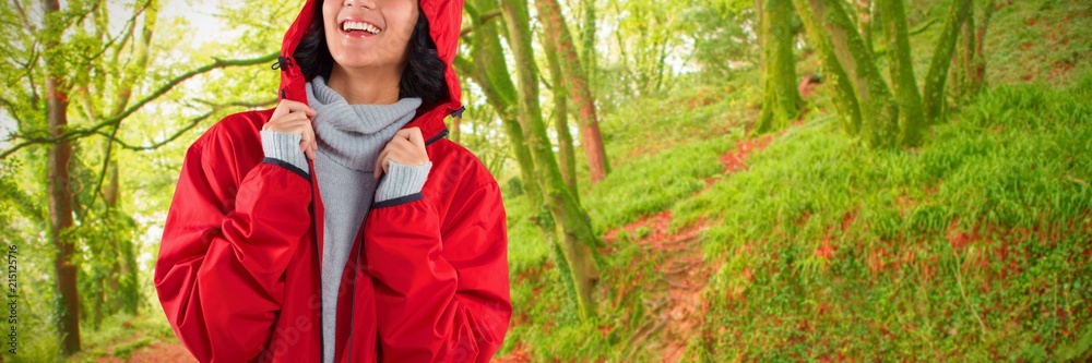 Composite image of woman in hooded jacket standing against white