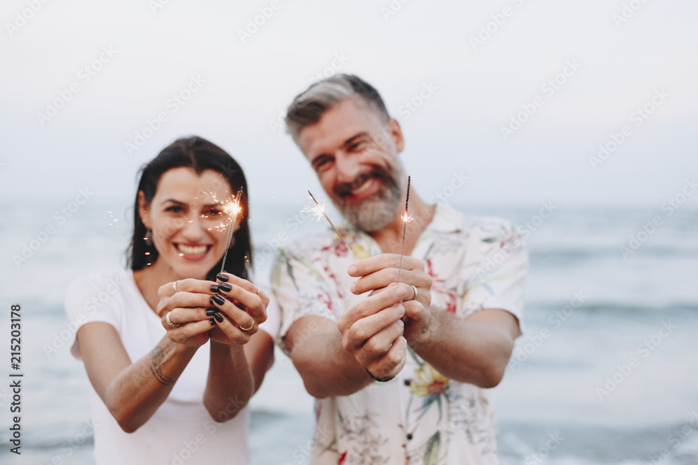 Couple celebrating with sparklers at the beach