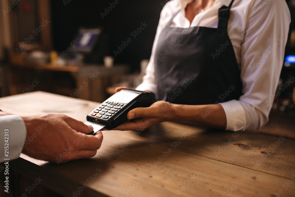 Man paying for coffee by credit card at coffee shop