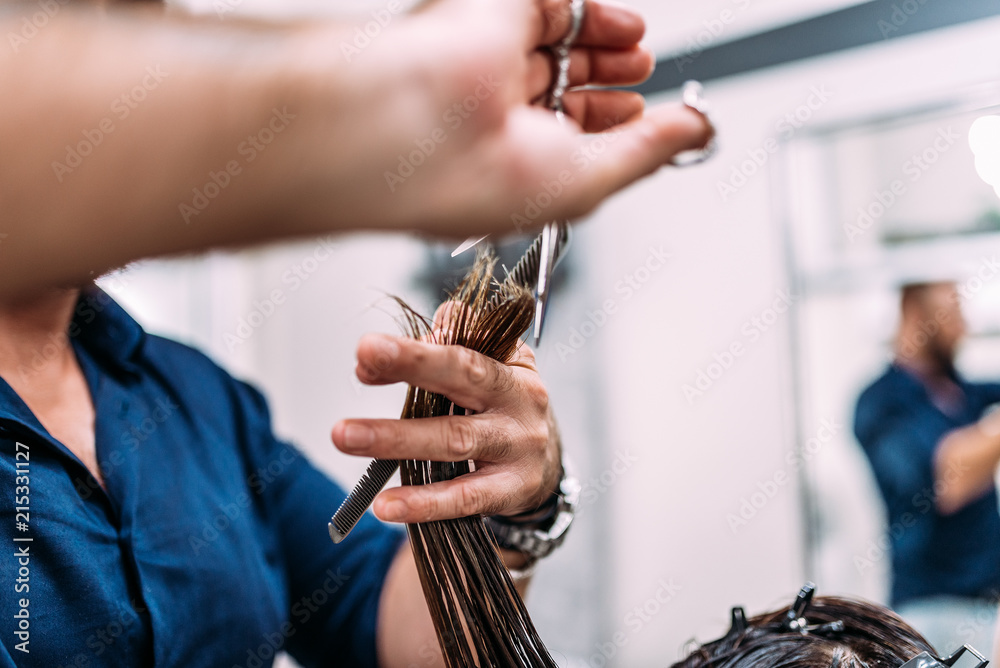 Close-up image of hairdresser giving a new haircut to female customer.