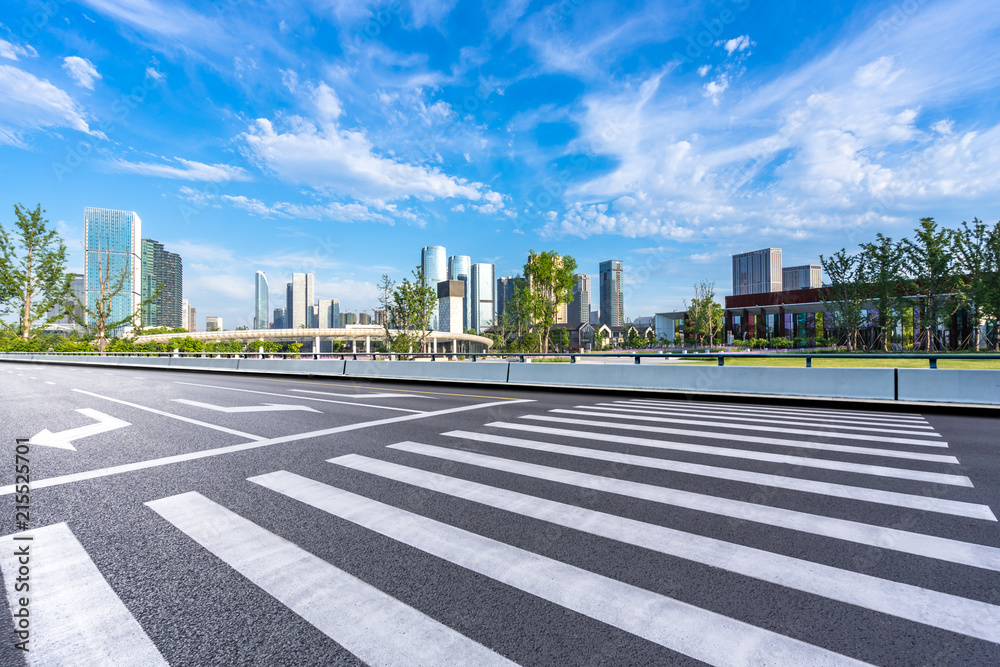 asphalt road with city skyline