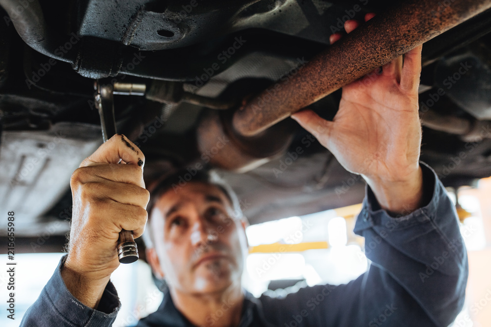 Auto mechanic repairing a car in service station