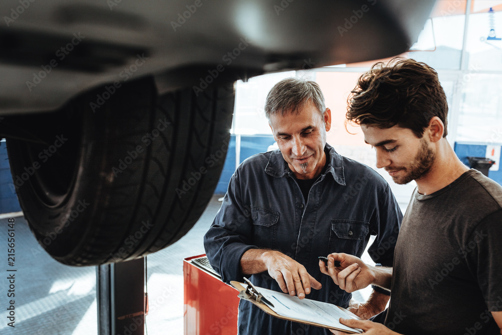 Mechanics making notes of problems in car