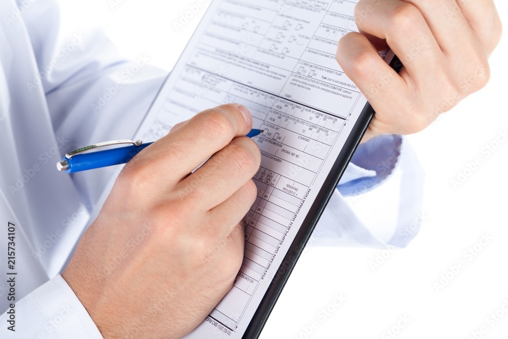 Hand Filling a Health Insurance Document with Stethoscope