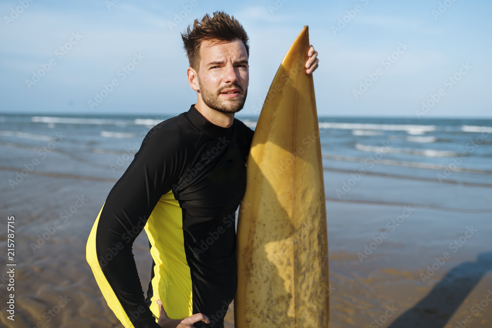 海滩上有冲浪板的男人