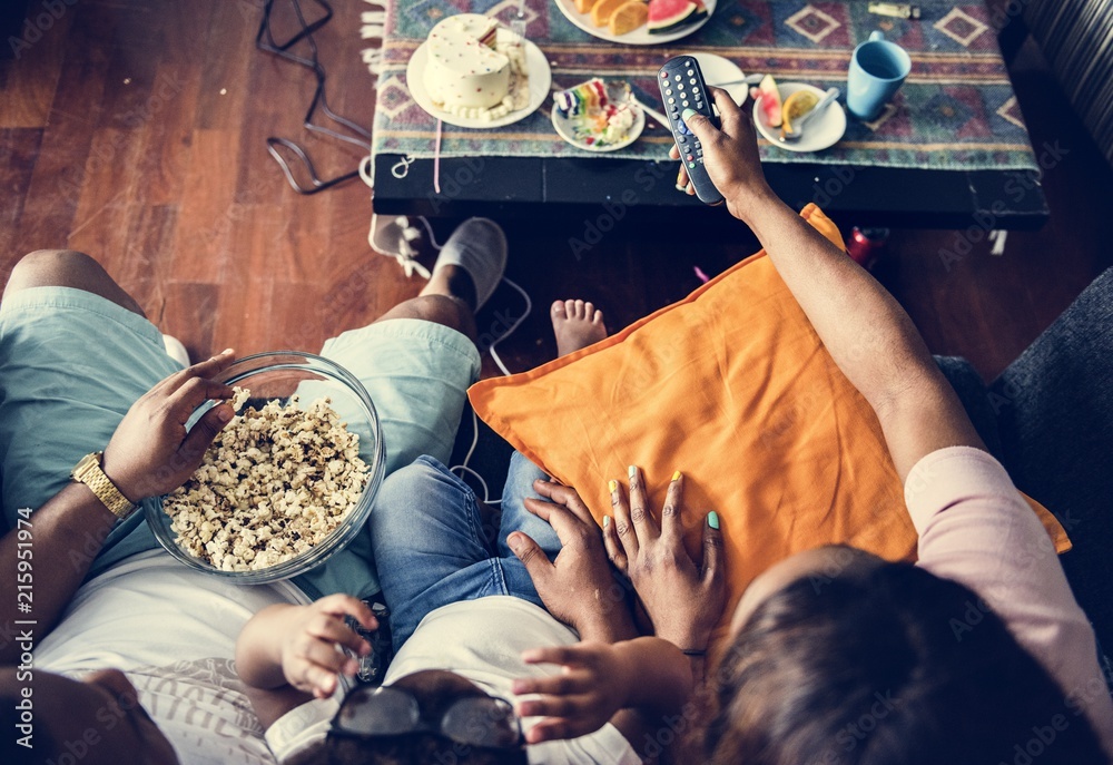 Family eating popcorn and watching TV